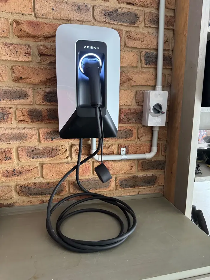 EV charger mounted on a brick wall in a carport