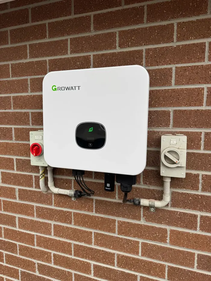 Growatt solar inverter mounted neatly on a brick wall